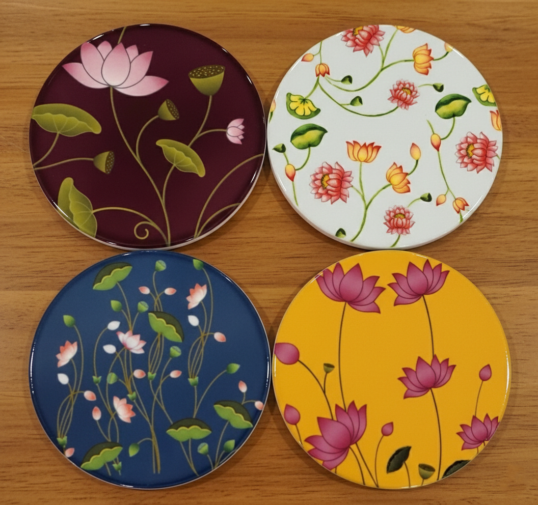 Four round coasters with floral designs on a wooden surface
