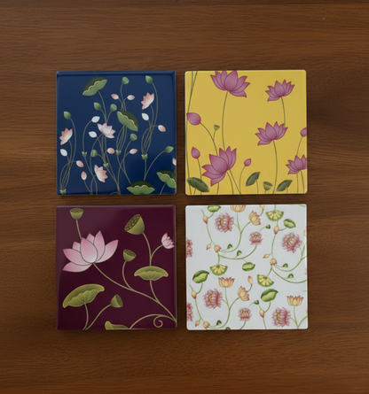 Four floral coasters with different color schemes on a wooden surface