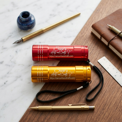 Two metallic pens, one red and one gold, on a wooden surface with a marble background.