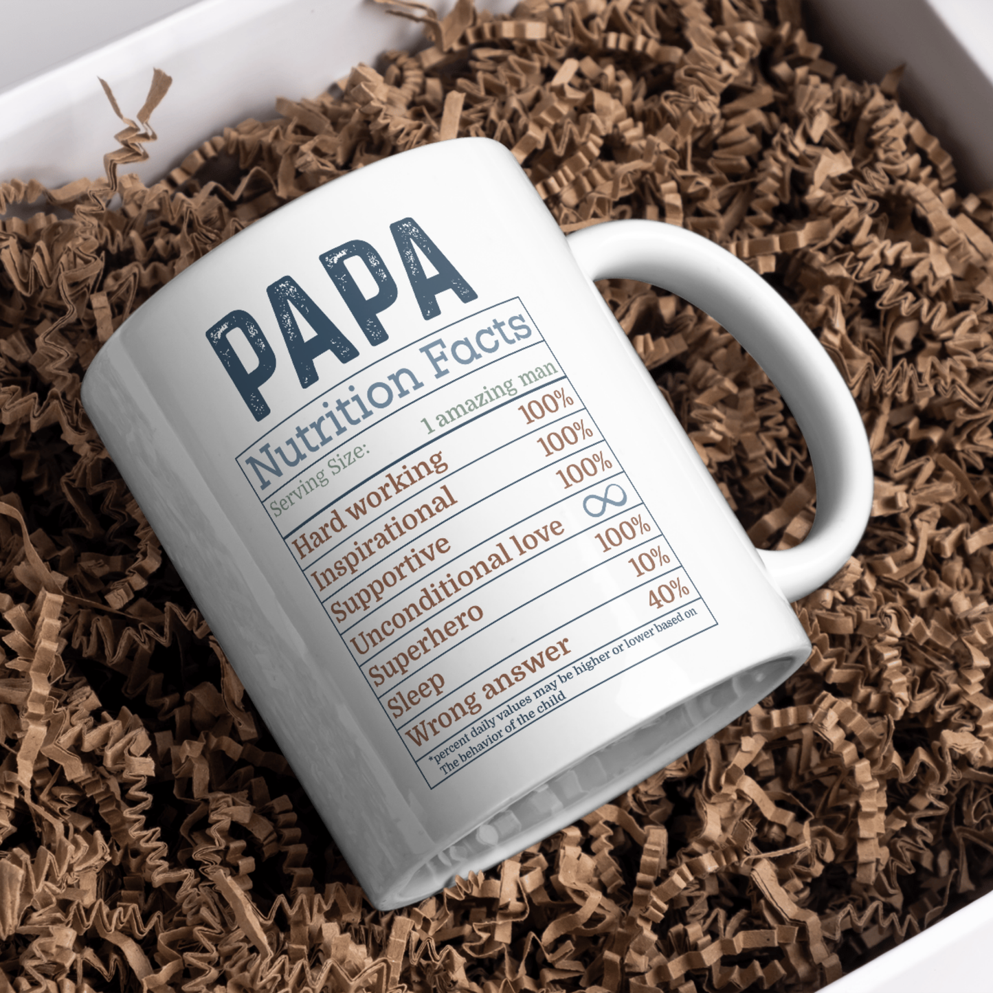 White mug with 'PAPA Nutrition Facts' text on a bed of brown crinkle paper