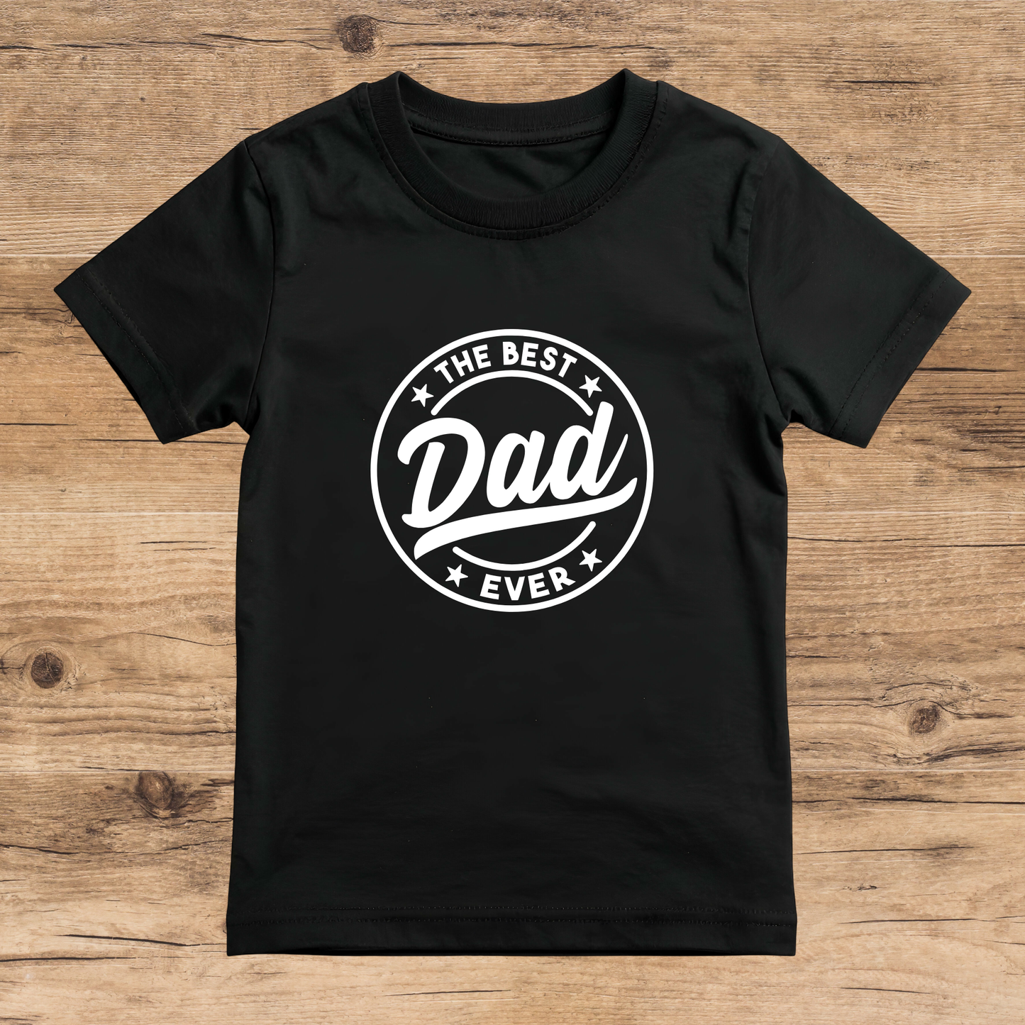 Black t-shirt with 'The Best Dad Ever' text on a wooden surface