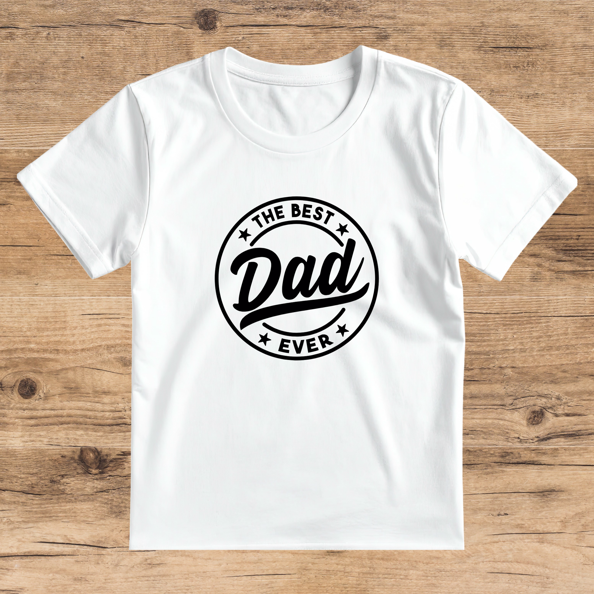 White t-shirt with 'The Best Dad Ever' text on a wooden surface