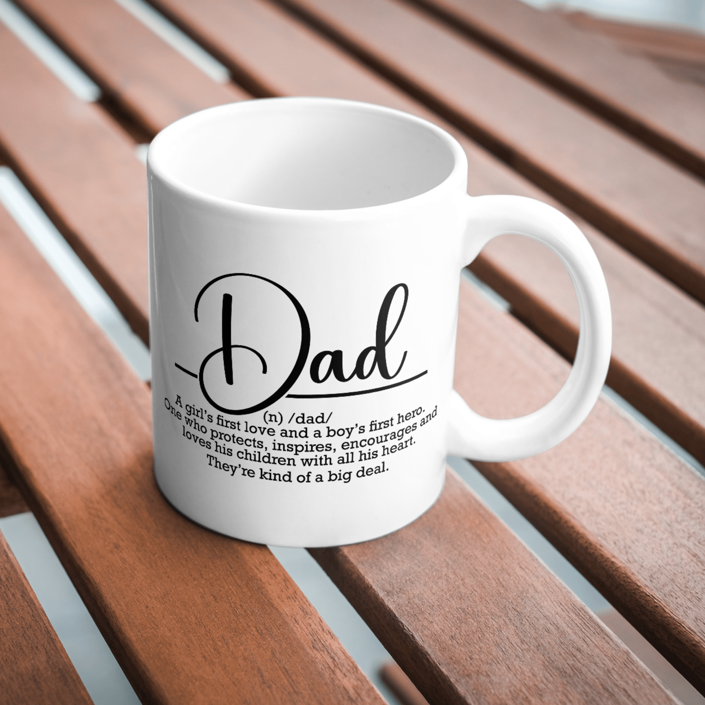 White mug with 'Dad' definition text on a wooden surface