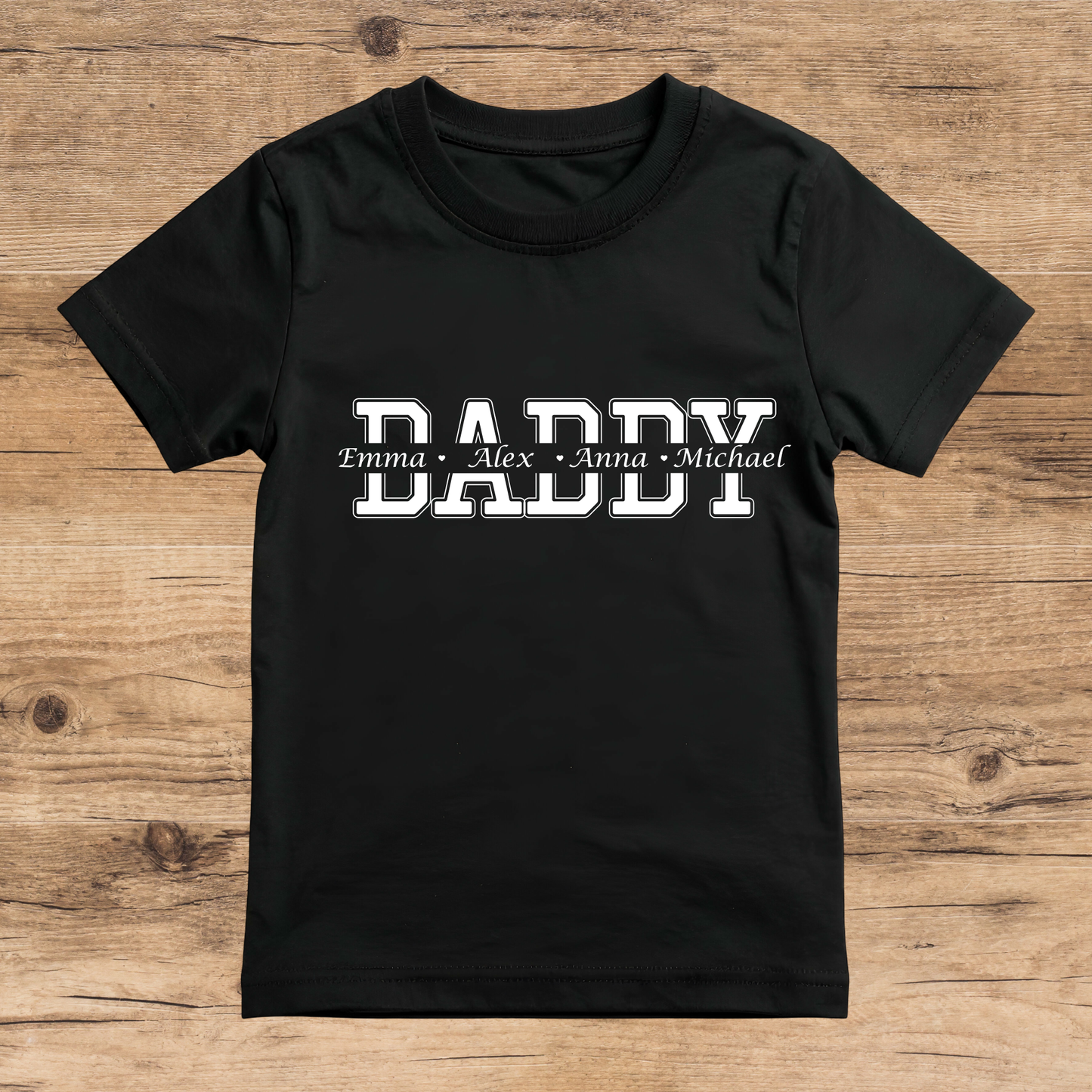 Black t-shirt with 'DADDY' and names printed on a wooden surface