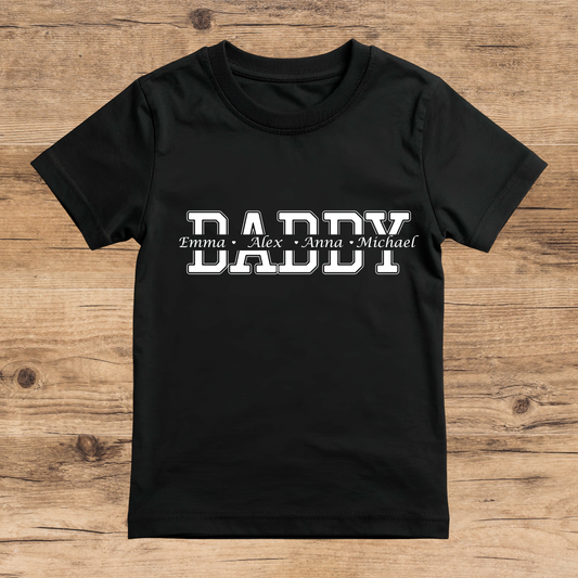 Black t-shirt with 'DADDY' and names printed on a wooden surface