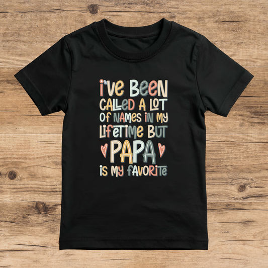 Black t-shirt with colorful text on a wooden surface