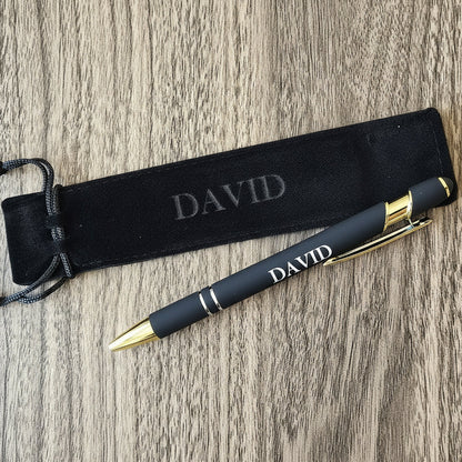 Black pen with gold accents and 'DAVID' engraving on a wooden surface