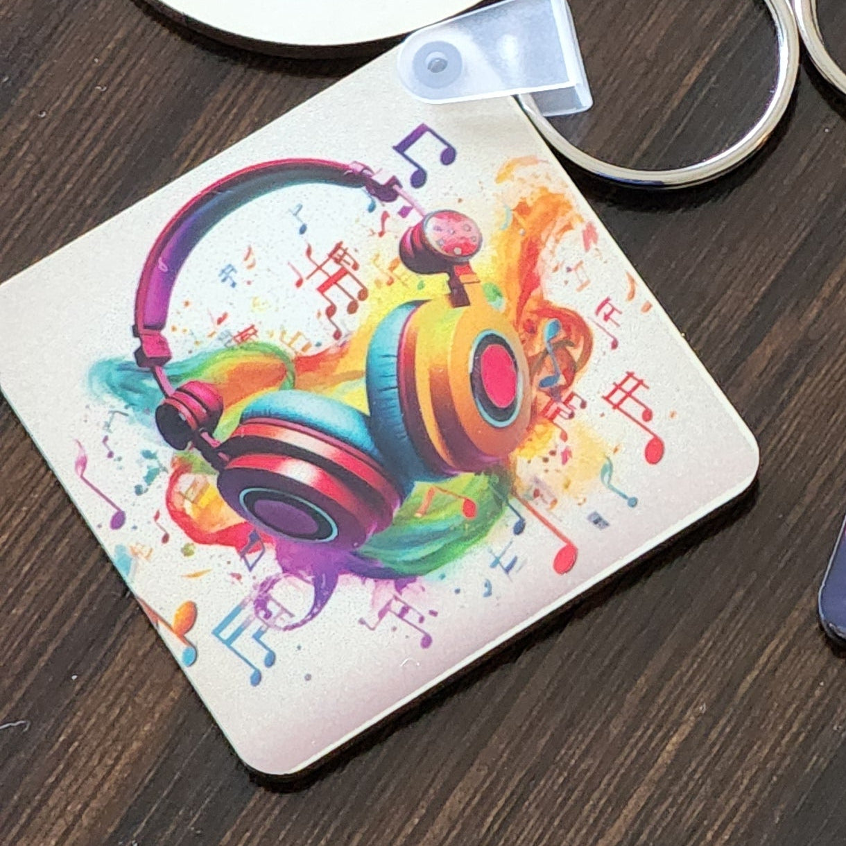 Set of keychains with colorful designs on a wooden surface