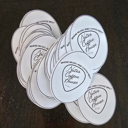 Stickers with 'Notes Coffee House' text on a dark surface