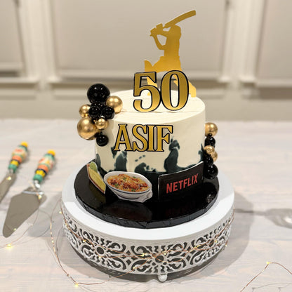 Birthday cake with '50 ASIF' and Netflix logo, decorated with gold and black elements.