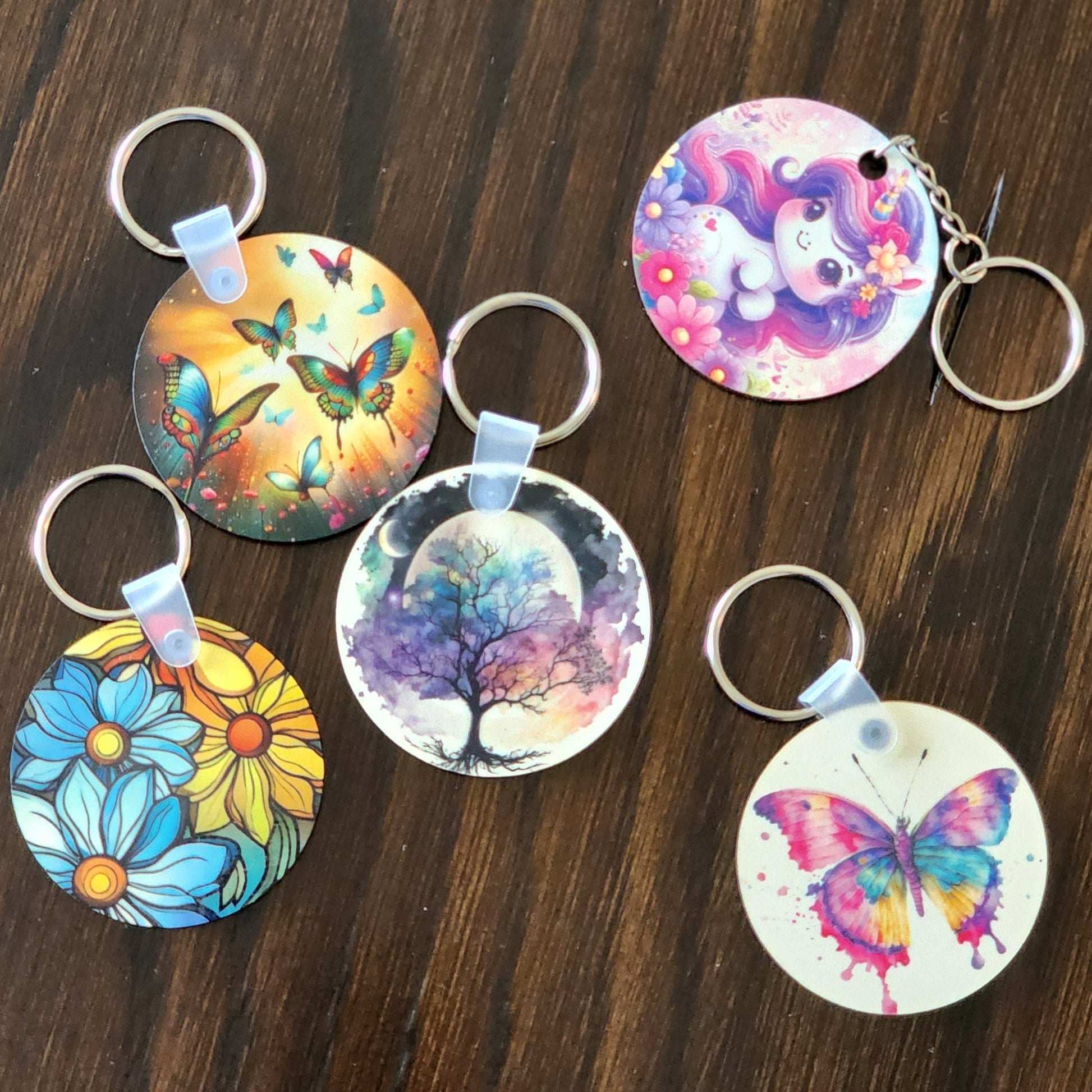 Colorful keychains with various designs on a wooden surface